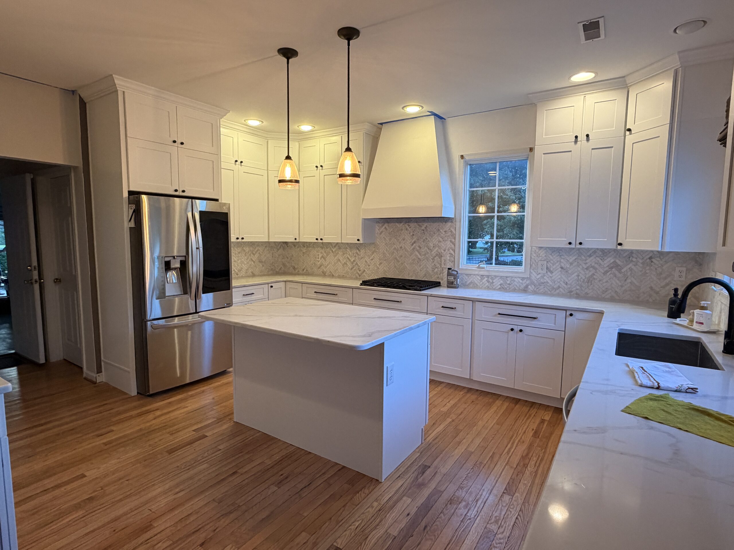 White cabinetry and central island in a complete Philadelphia kitchen remodel by Cuadros Construction