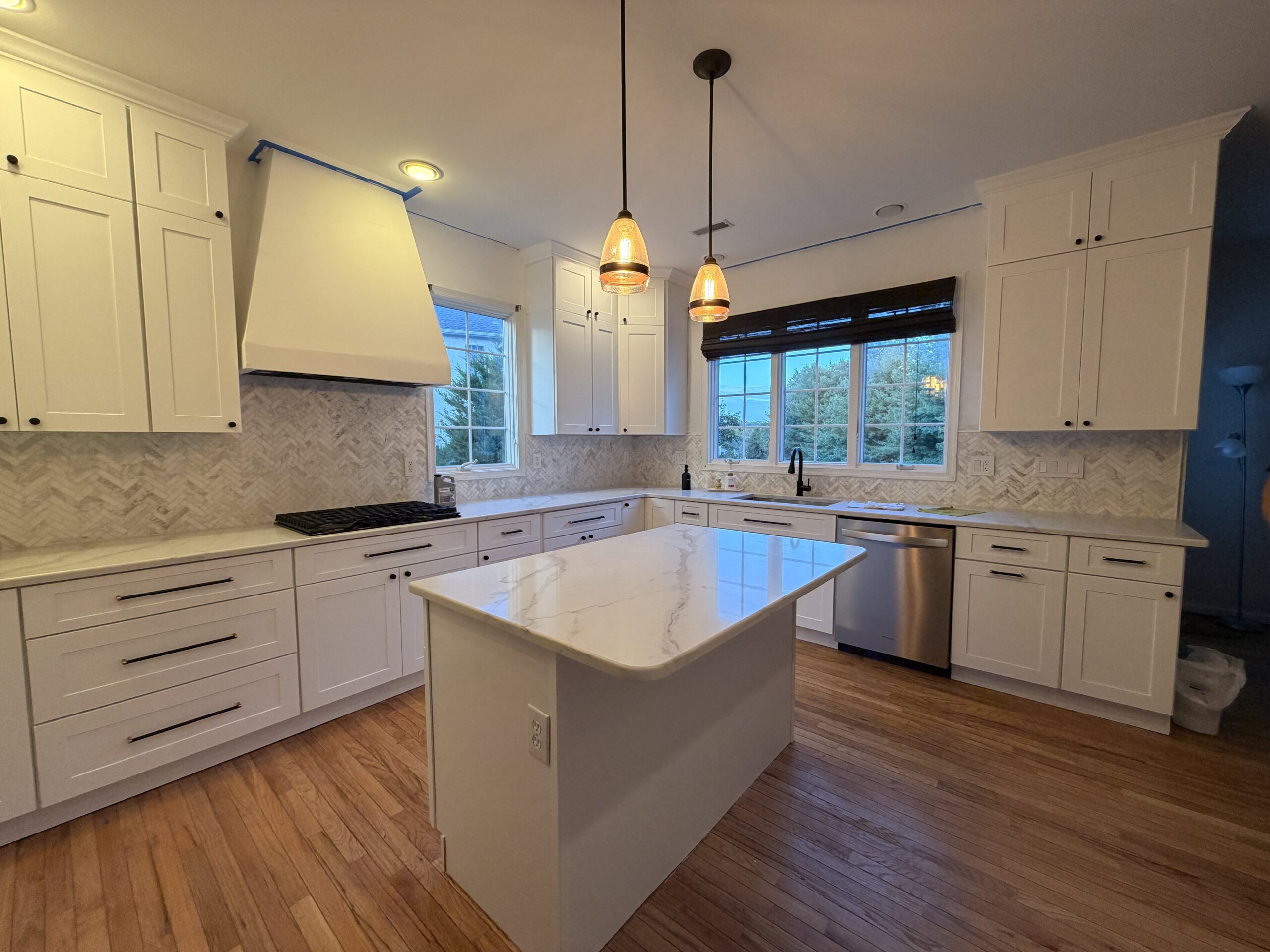 Philadelphia kitchen with central island, white cabinets, dark faucet and stainless steel dishwasher